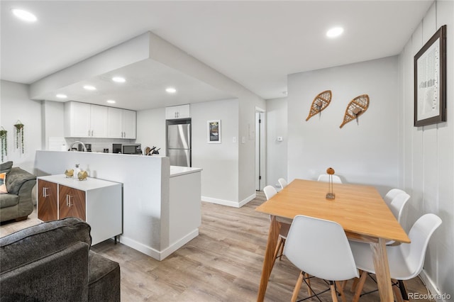 370 E Ln Bonte St Unit 502, Dillon, CO 80435 - kitchen featuring a peninsula, recessed lighting, light wood-style floors, stainless steel appliances, and white cabinetry