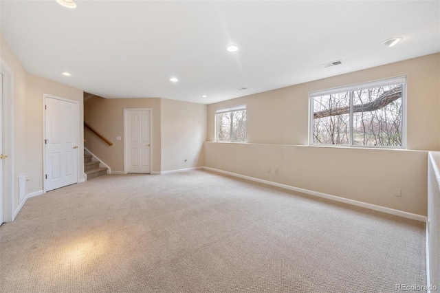unfurnished room with stairway, light colored carpet, baseboards, visible vents, and recessed lighting
