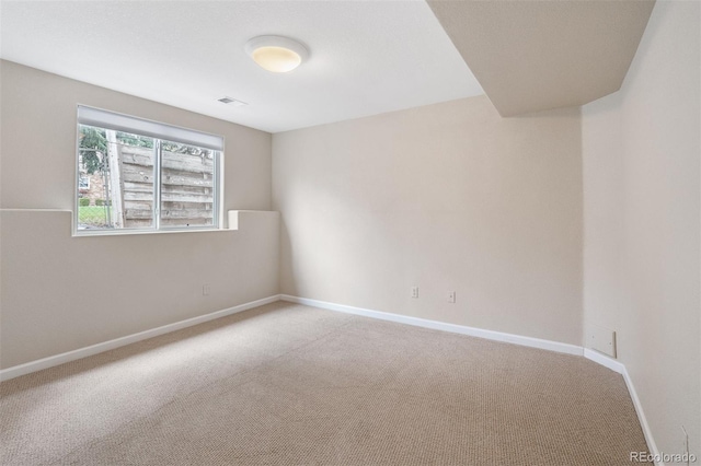 empty room featuring light carpet, baseboards, and visible vents