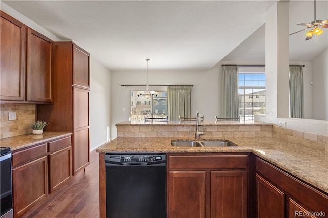 kitchen featuring sink, dishwasher, tasteful backsplash, light stone countertops, and dark hardwood / wood-style flooring