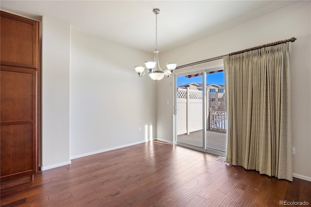 empty room with an inviting chandelier and dark wood-type flooring