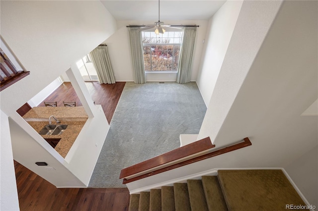 stairway featuring sink and ceiling fan