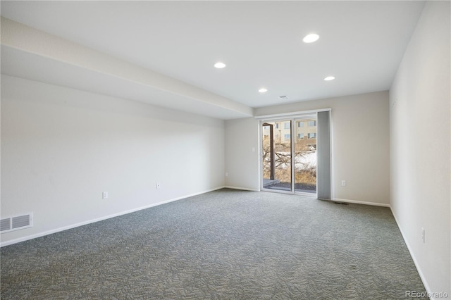 spare room featuring dark colored carpet