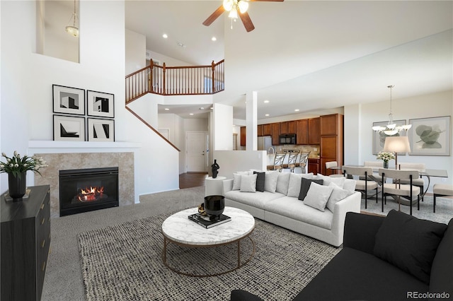 living room featuring a towering ceiling and ceiling fan with notable chandelier