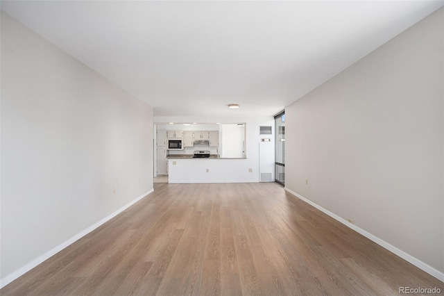 1625 Larimer St Unit 1001, Denver, CO 80202 - unfurnished living room featuring light wood-style flooring and baseboards