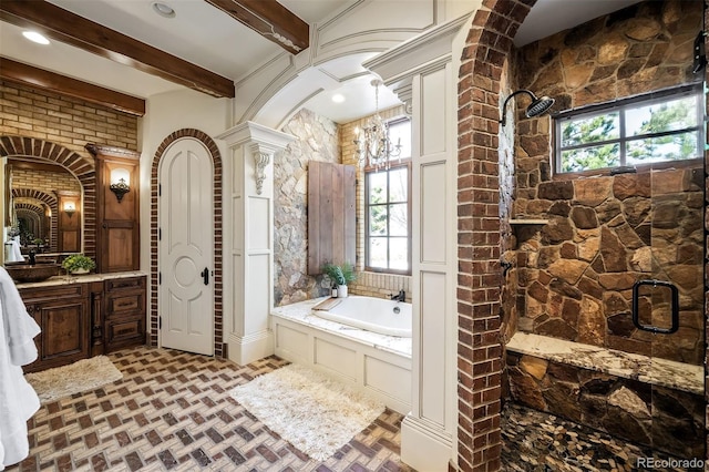 bathroom with decorative columns, a chandelier, beam ceiling, vanity, and separate shower and tub