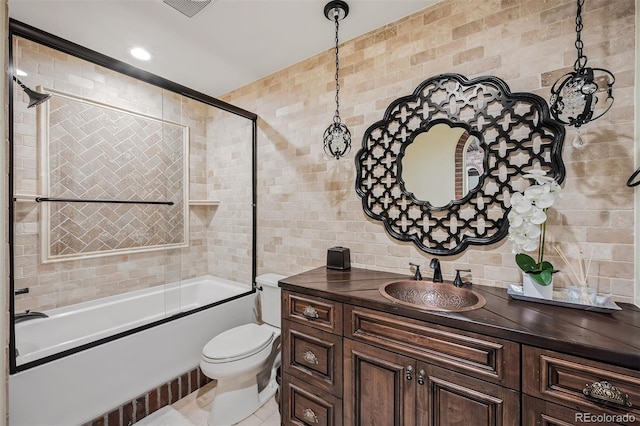 full bathroom with vanity, toilet, combined bath / shower with glass door, and tile walls