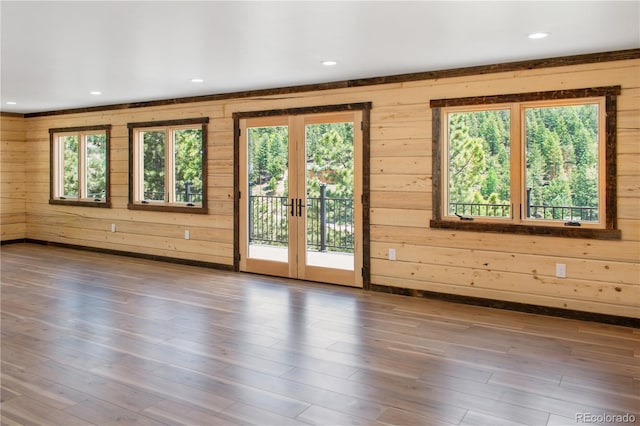 entryway featuring hardwood / wood-style flooring, a wealth of natural light, and wooden walls