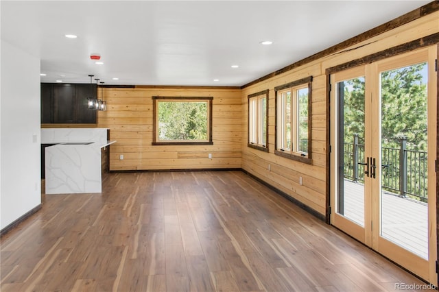 unfurnished living room with dark hardwood / wood-style floors and wood walls