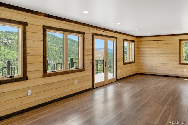 entryway with a mountain view, plenty of natural light, hardwood / wood-style floors, and french doors