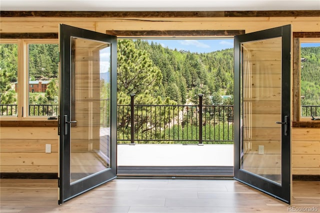 entryway featuring wooden walls, french doors, and a healthy amount of sunlight