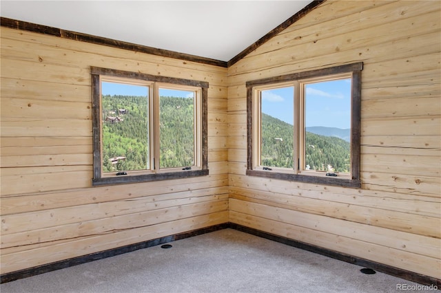 spare room featuring carpet floors, a mountain view, and vaulted ceiling