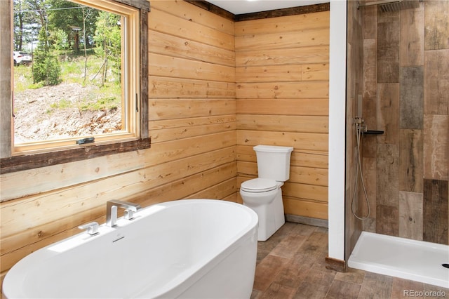 bathroom featuring wooden walls, shower with separate bathtub, and toilet