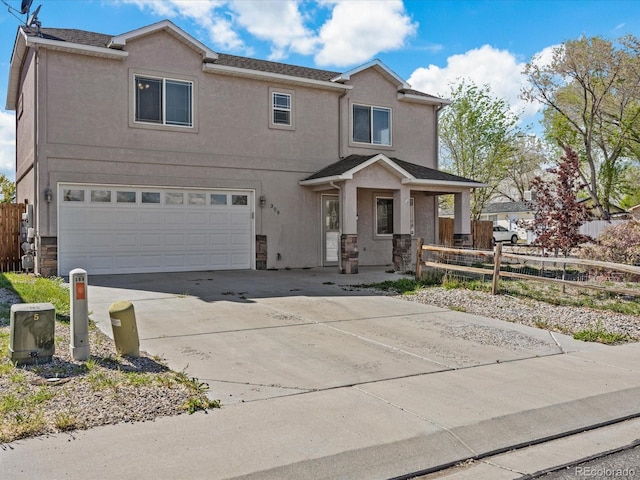 traditional-style home featuring fence, driveway, stucco siding, and a garage