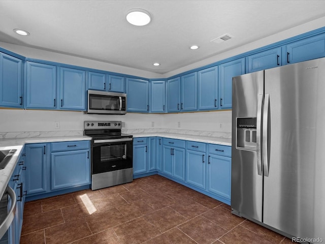 kitchen with blue cabinets, light stone counters, recessed lighting, and appliances with stainless steel finishes