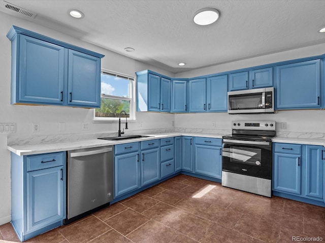 kitchen with a sink, blue cabinets, stainless steel appliances, visible vents, and recessed lighting