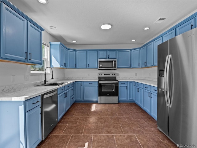 kitchen with recessed lighting, blue cabinetry, stainless steel appliances, and a sink
