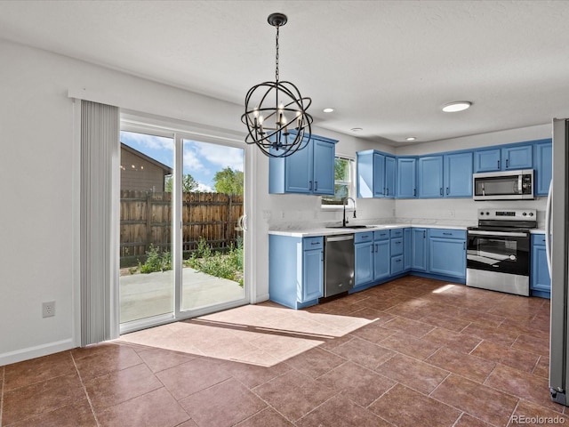 kitchen with stainless steel appliances, a sink, blue cabinetry, and a healthy amount of sunlight