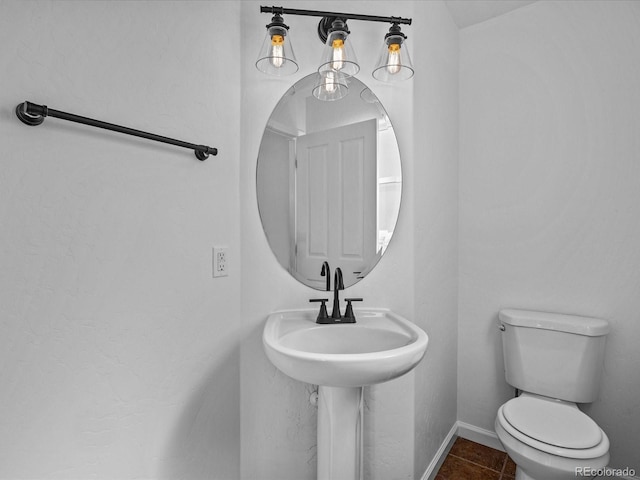 bathroom with baseboards and toilet