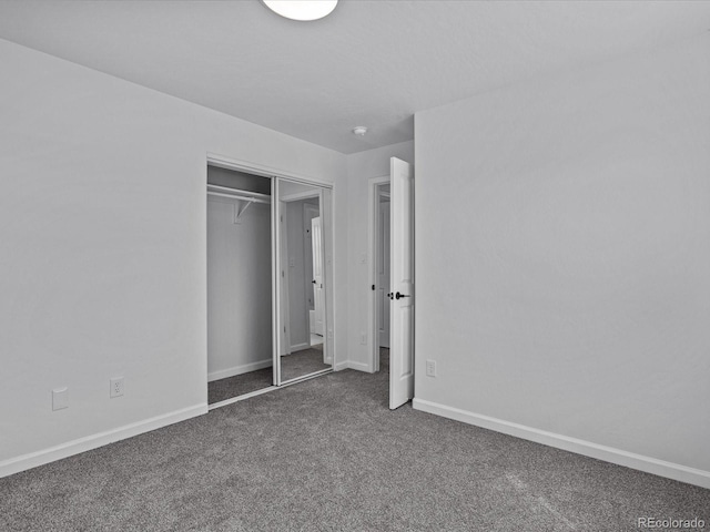 unfurnished bedroom featuring carpet floors, a closet, and baseboards