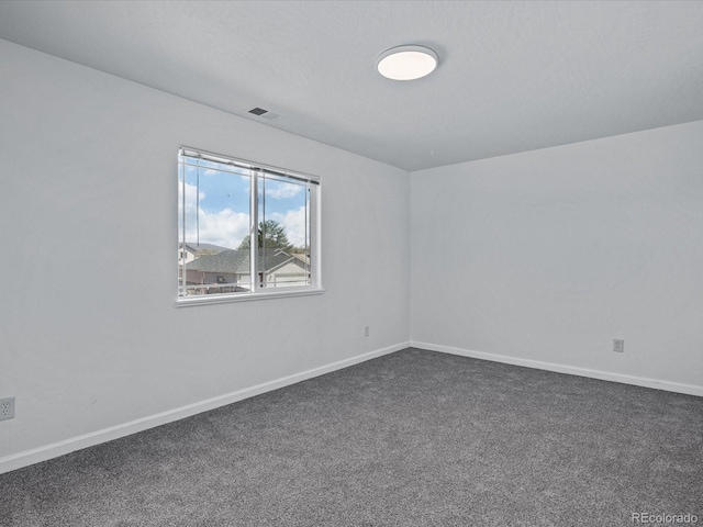 spare room with carpet, visible vents, and baseboards