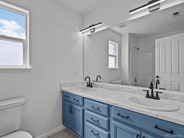 full bath with visible vents, a sink, double vanity, and toilet