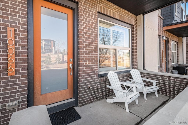 view of exterior entry featuring brick siding