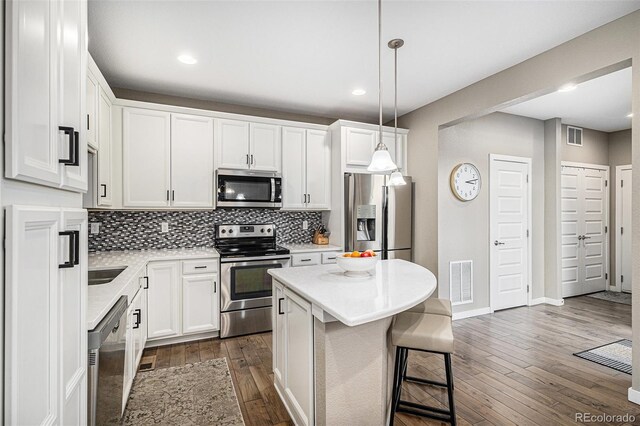 10066 Belvedere Cir, Lone Tree, CO 80124 - kitchen featuring tasteful backsplash, visible vents, dark wood finished floors, light countertops, and appliances with stainless steel finishes