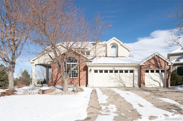 traditional home with driveway and brick siding