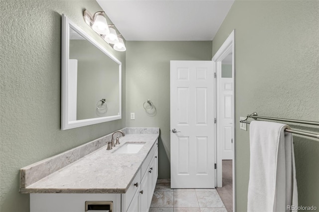 bathroom featuring a textured wall, tile patterned floors, and vanity