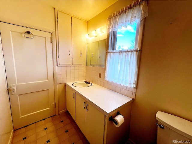 bathroom featuring tasteful backsplash, vanity, and toilet