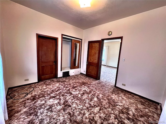 unfurnished bedroom with visible vents, baseboards, dark colored carpet, and a textured ceiling