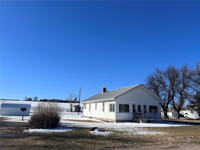 view of front of home featuring metal roof and a chimney