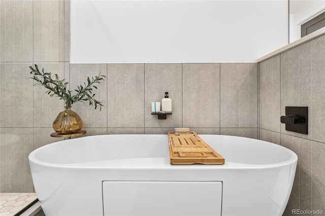 bathroom with a soaking tub and tile walls