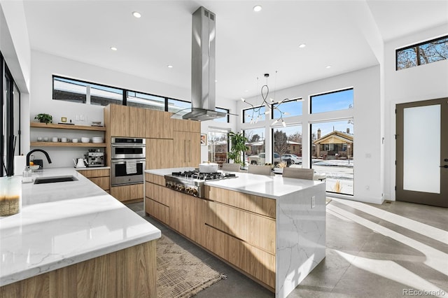 kitchen with modern cabinets, a sink, open shelves, appliances with stainless steel finishes, and island range hood