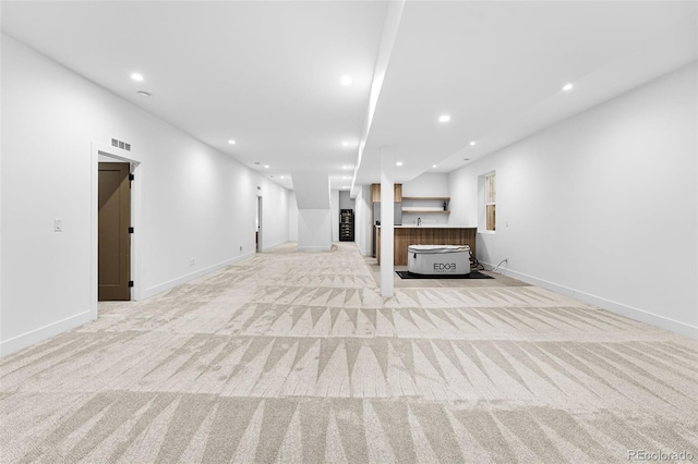 unfurnished living room featuring recessed lighting, visible vents, light carpet, and baseboards