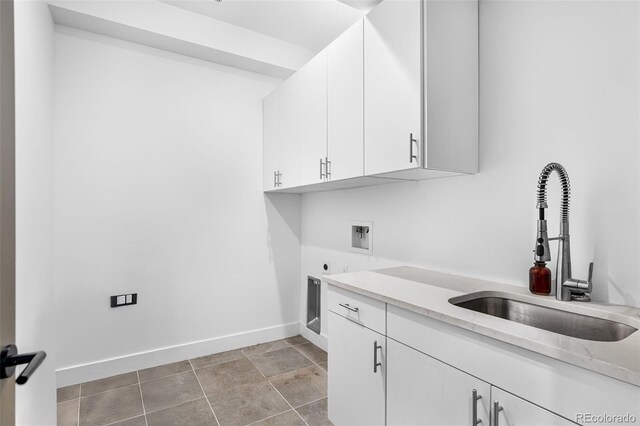 laundry area featuring electric dryer hookup, washer hookup, a sink, cabinet space, and baseboards