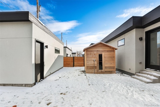 yard covered in snow featuring an outdoor structure, fence, and a shed