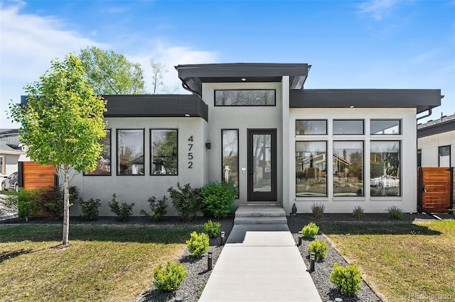 entrance to property with a yard and stucco siding