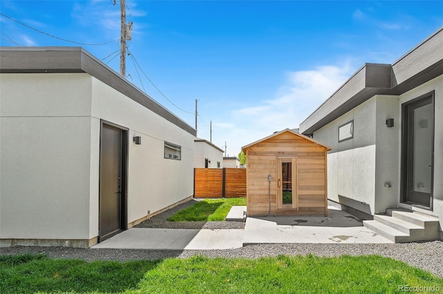 view of yard with an outdoor structure, entry steps, a shed, and fence