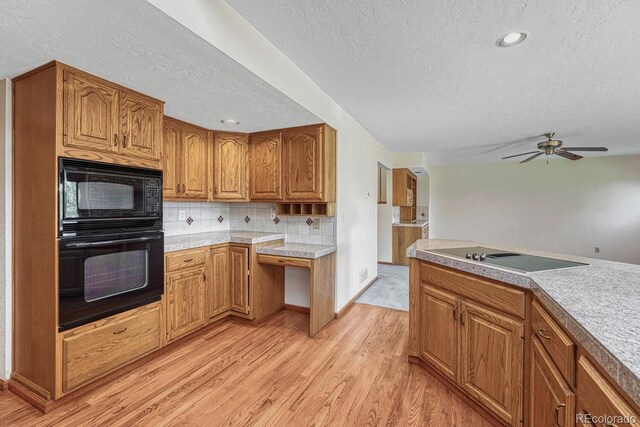 kitchen featuring ceiling fan, a textured ceiling, backsplash, black appliances, and light wood-type flooring