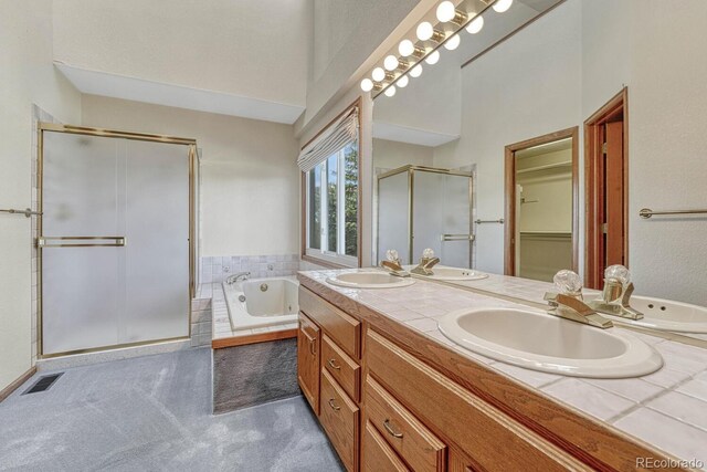 bathroom featuring shower with separate bathtub and vanity