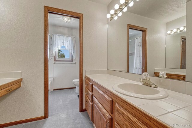 bathroom with vanity, toilet, a textured ceiling, and a shower with shower curtain