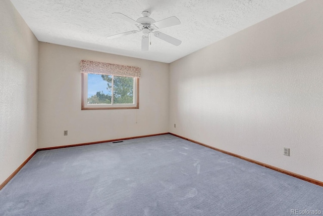 carpeted empty room with ceiling fan and a textured ceiling