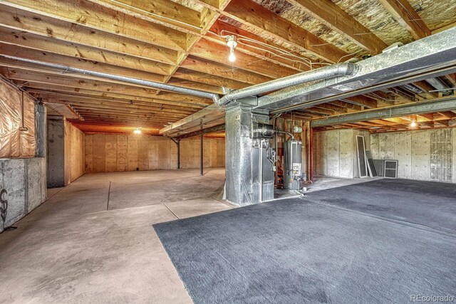 basement featuring heating unit and water heater