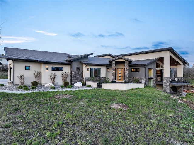 3585 Meadow Run Cir, Colorado Springs, CO 80908 - rear view of property with stone siding, stucco siding, and a lawn