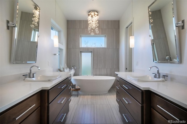 3585 Meadow Run Cir, Colorado Springs, CO 80908 - full bathroom with a freestanding bath, tile walls, two vanities, and a chandelier