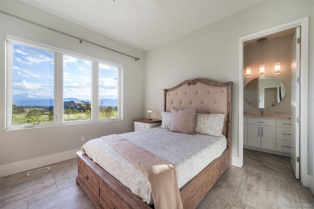 3585 Meadow Run Cir, Colorado Springs, CO 80908 - bedroom with ensuite bath, a sink, a mountain view, and baseboards