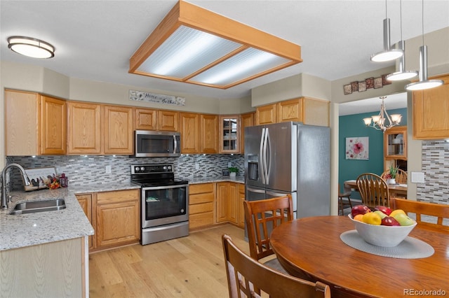 17018 Carr Ave, Parker, CO 80134 - kitchen featuring appliances with stainless steel finishes, a sink, tasteful backsplash, light wood-style floors, and a chandelier