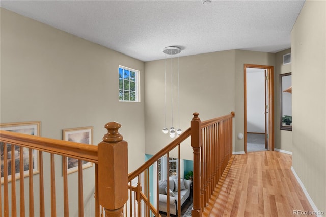 17018 Carr Ave, Parker, CO 80134 - corridor featuring an upstairs landing, wood finished floors, a textured ceiling, and baseboards